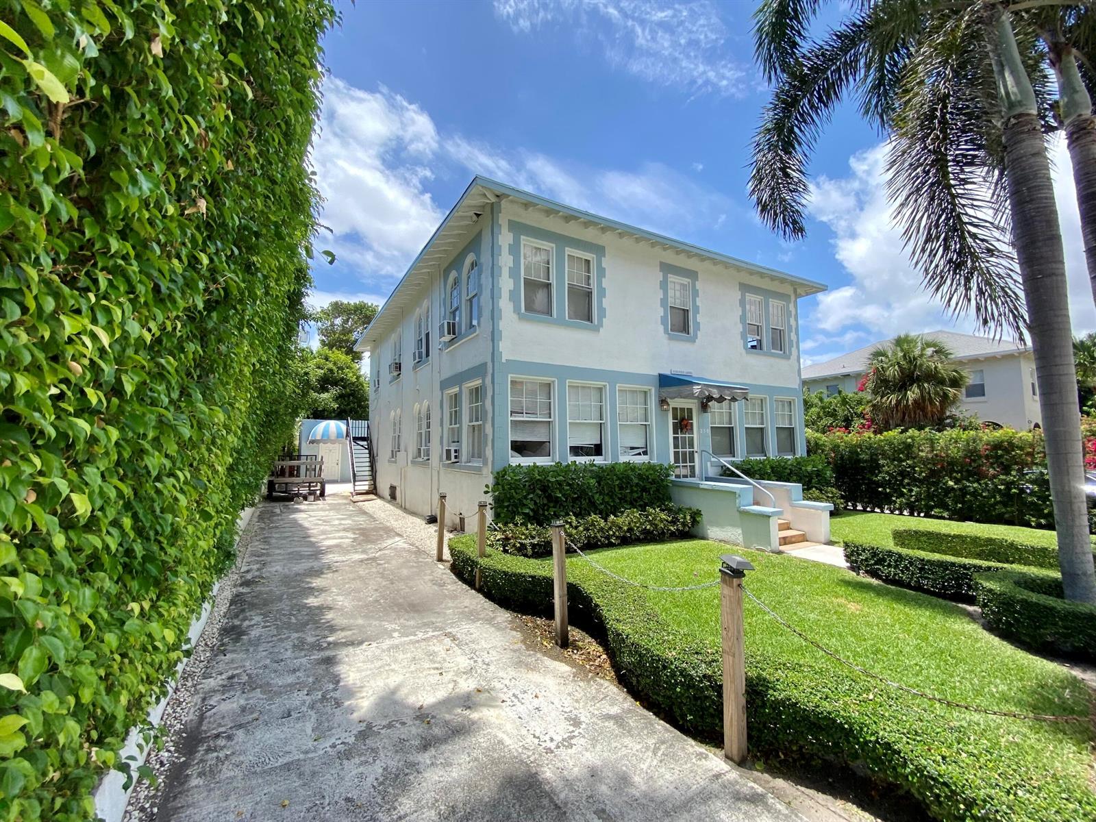A two-story white house with blue trim features a driveway and manicured hedges — 250 Seminole Avenue # 3, Palm Beach FL 33480, PALM BEACH, FL