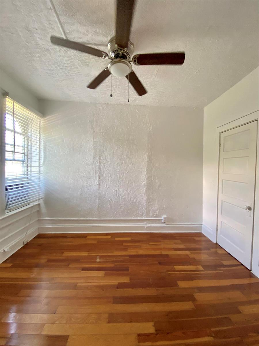 An empty room with hardwood floors, white walls, a ceiling fan, and a white door — 250 Seminole Avenue # 3, Palm Beach FL 33480, PALM BEACH, FL