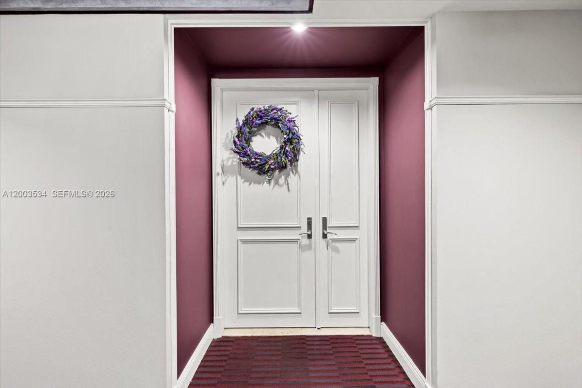 A double white door with a floral wreath sits in a recessed, dark-walled entryway — 808 BRICKELL KEY DR # 1205, Miami FL 33131, MIAMI, FL