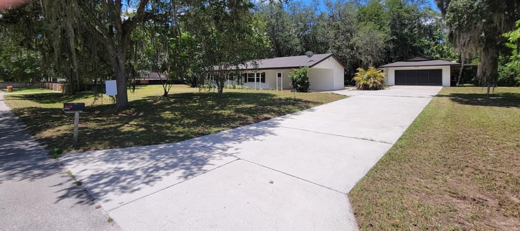 A single-story house with a white exterior, a concrete driveway, and a detached garage — 3036 LOWERY DRIVE, OVIEDO, FL