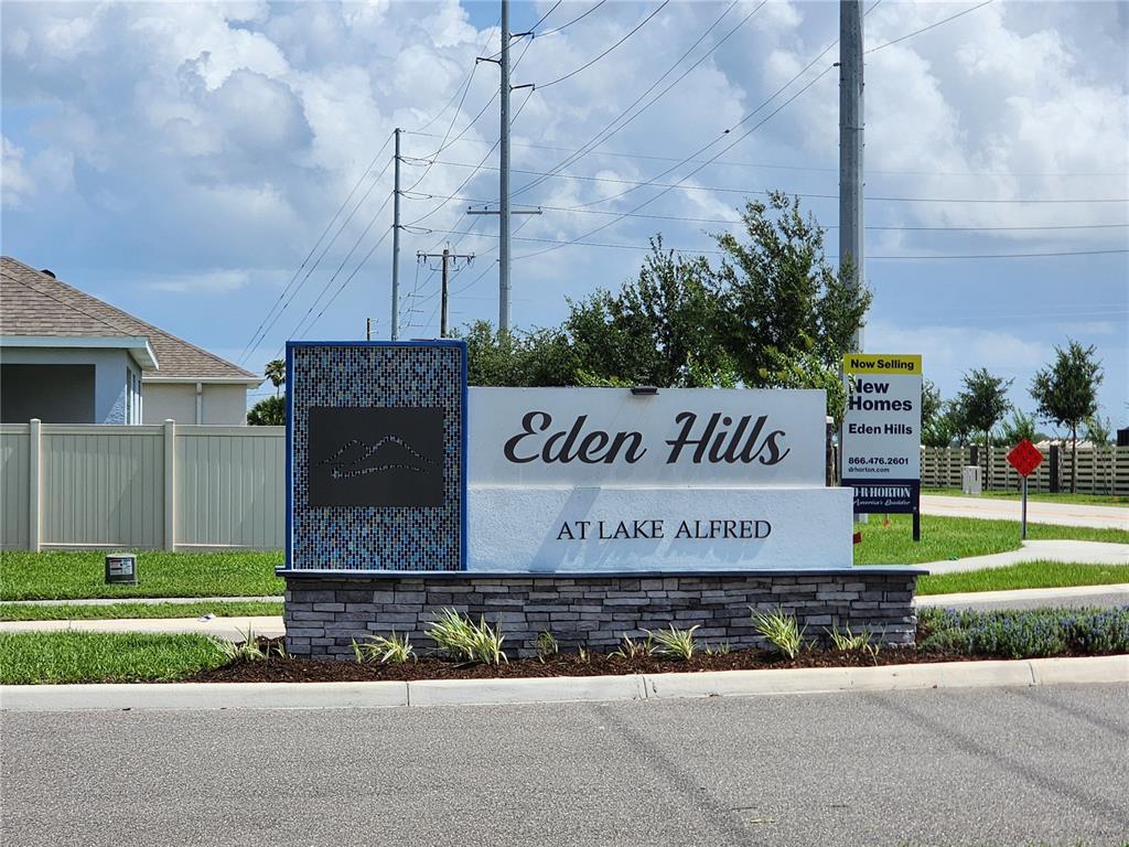 A stone and stucco monument sign for the Eden Hills community stands near a road — 708 GRIFFON AVENUE, LAKE ALFRED, FL