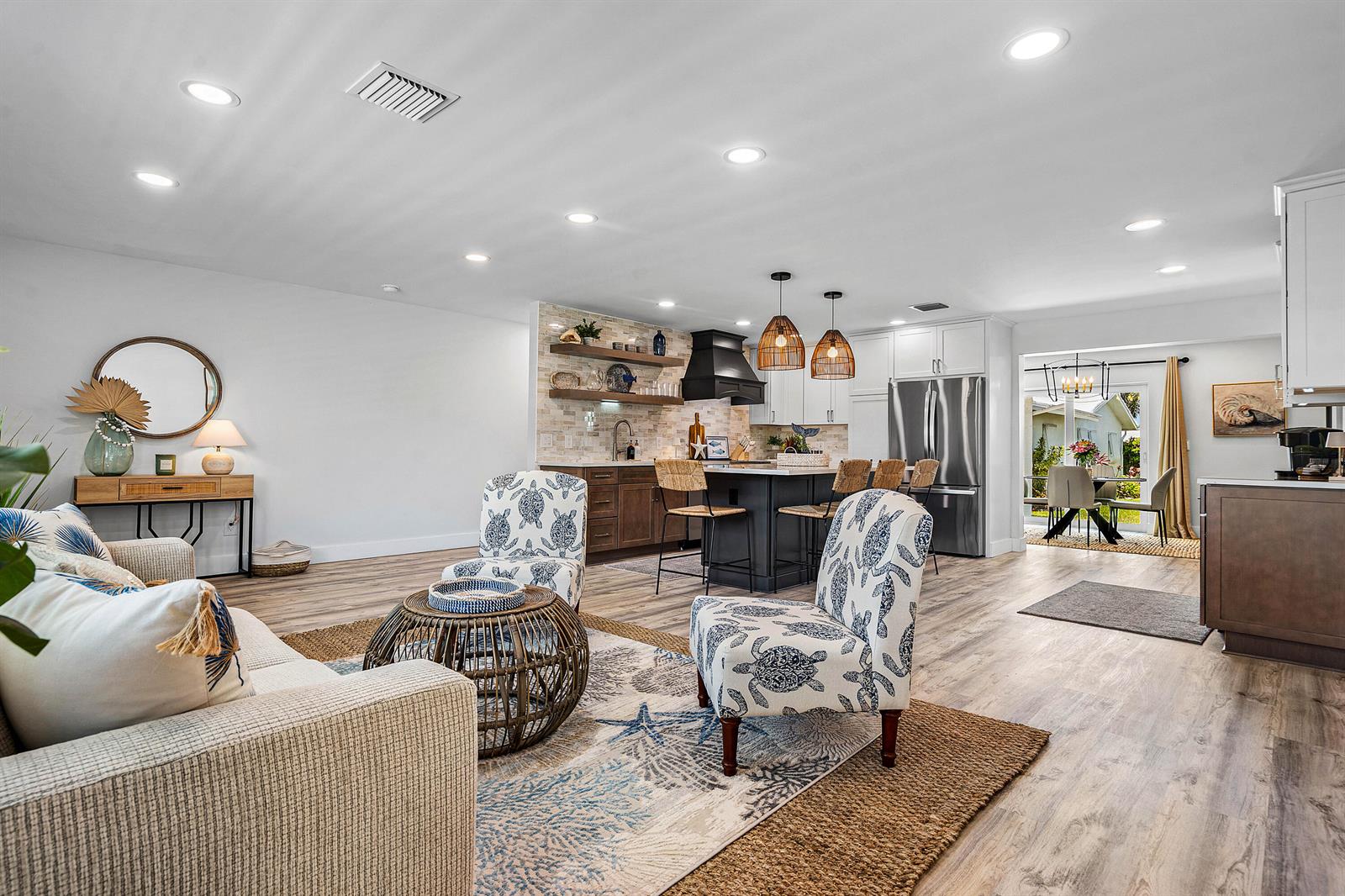 An open-concept living room and kitchen featuring coastal decor, wood-look flooring, and a kitchen island — 2015 SW 18th Drive, Boynton Beach FL 33426, BOYNTON BEACH, FL