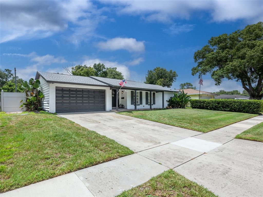A single-story white brick house with a dark garage door and a front porch — 1921 WINNEBAGO TRAIL, FERN PARK, FL