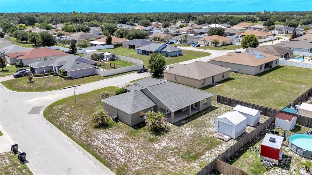 An aerial view shows a suburban house with a gray roof and a backyard shed — 265 MAJESTIC GARDENS LANE, WINTER HAVEN, FL