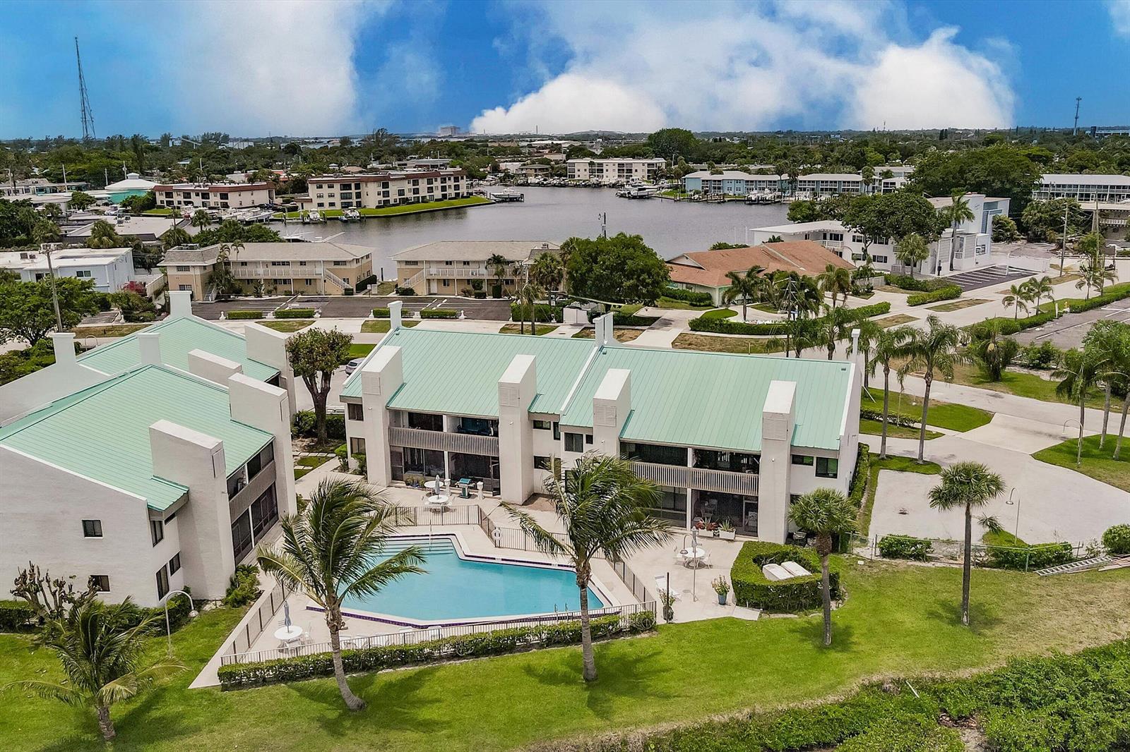 An aerial view of a multi-story apartment complex with a swimming pool and green roofs — 412 Southwind Drive # E2, North Palm Beach FL 33408, NORTH PALM BEACH, FL