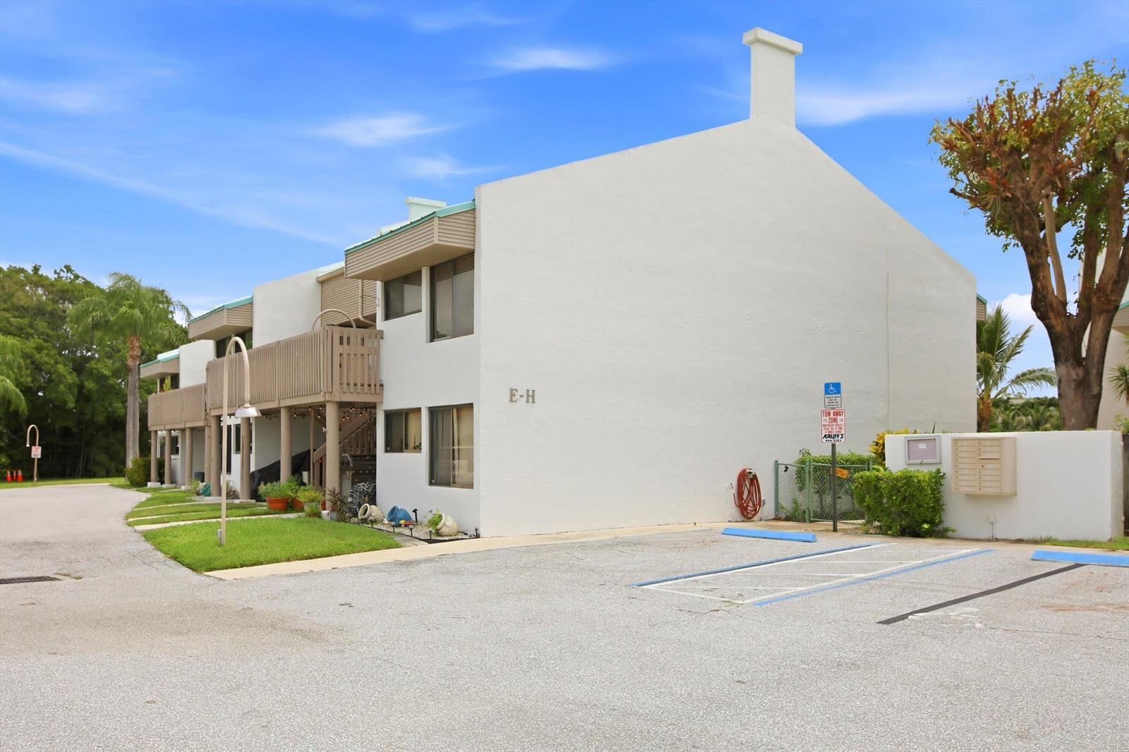 A two-story white stucco apartment building with a parking lot and a handicap sign — 412 Southwind Drive # E2, North Palm Beach FL 33408, NORTH PALM BEACH, FL