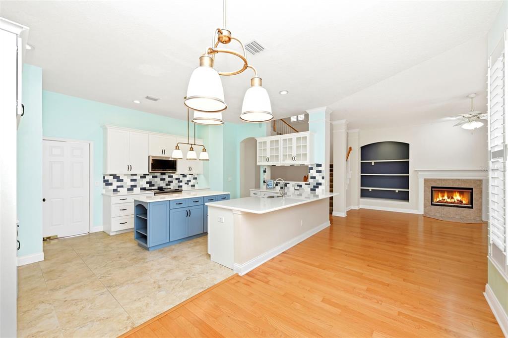 A kitchen with light blue walls, white cabinets, a blue island, and hardwood flooring — 1110 RUSH COURT, CELEBRATION, FL