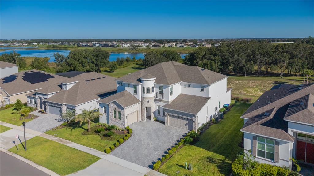 An aerial view of a two-story suburban house with a stone facade and paved driveway — 16077 BARKLY RIDGE COURT, WINTER GARDEN, FL