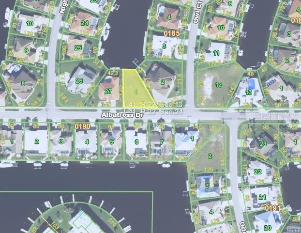 This is a satellite map view of a residential waterfront lot highlighted in yellow — 1566 ALBATROSS DRIVE, PUNTA GORDA, FL