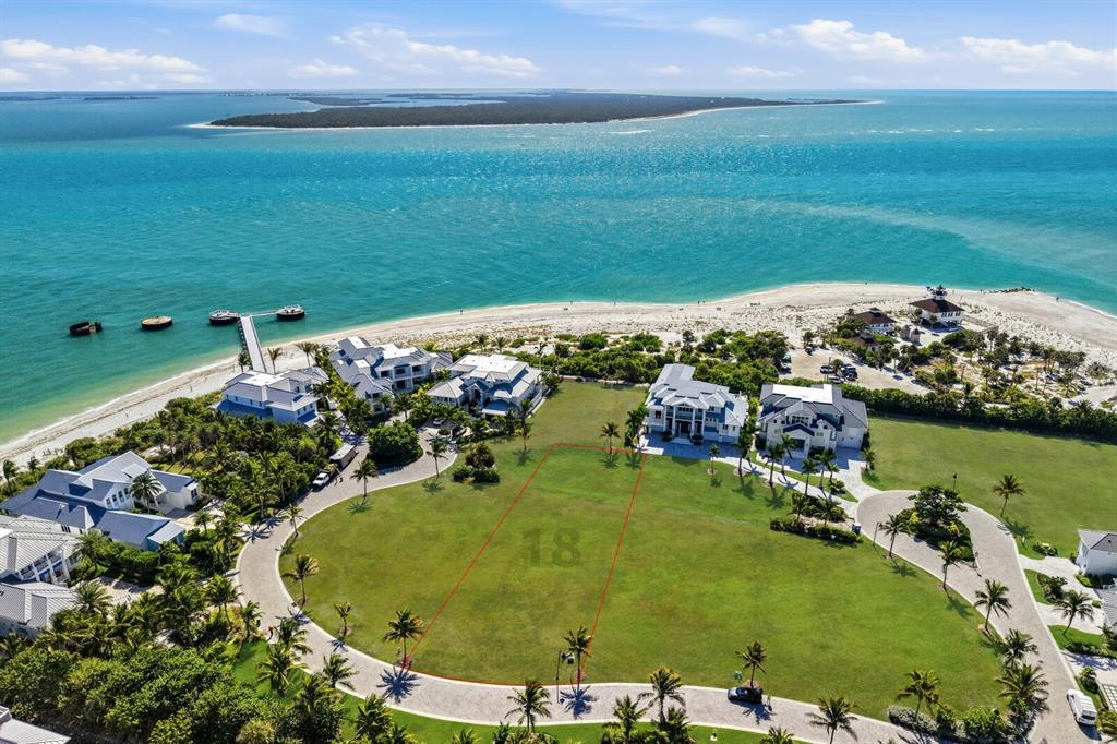 An aerial view shows a vacant, rectangular residential lot marked with red lines near a beach — 869 HILL TIDE LANE, BOCA GRANDE, FL