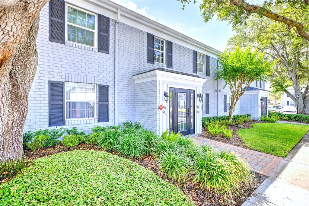 A two-story brick apartment building with dark shutters and a central glass-paned entryway — 262 LEWFIELD CIRCLE UNIT 262, WINTER PARK, FL