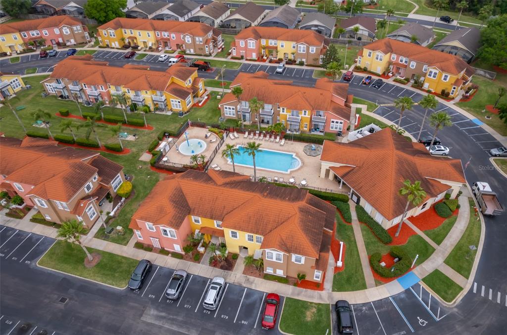 An aerial view shows a residential complex with multi-story buildings, a swimming pool, and parking — 979 PARK TERRACE CIRCLE, KISSIMMEE, FL