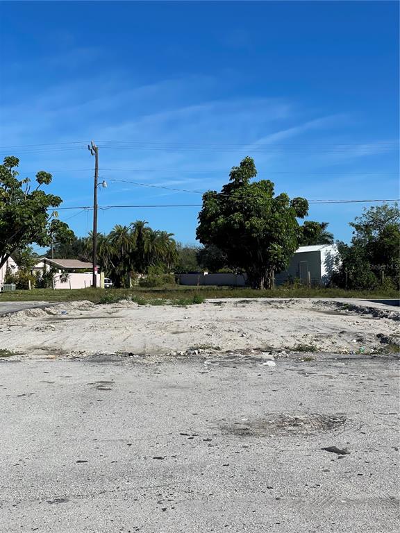 A vacant, cleared lot with sandy ground, a utility pole, and surrounding trees and buildings — 3782 TAMIAMI TRAIL UNIT B, PORT CHARLOTTE, FL