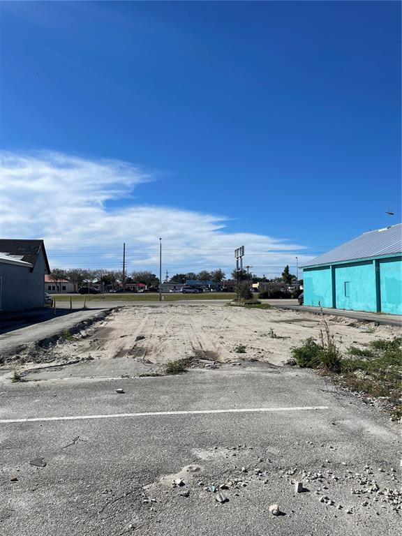 A vacant, dirt-covered lot sits between two commercial buildings under a clear blue sky — 3782 TAMIAMI TRAIL UNIT B, PORT CHARLOTTE, FL