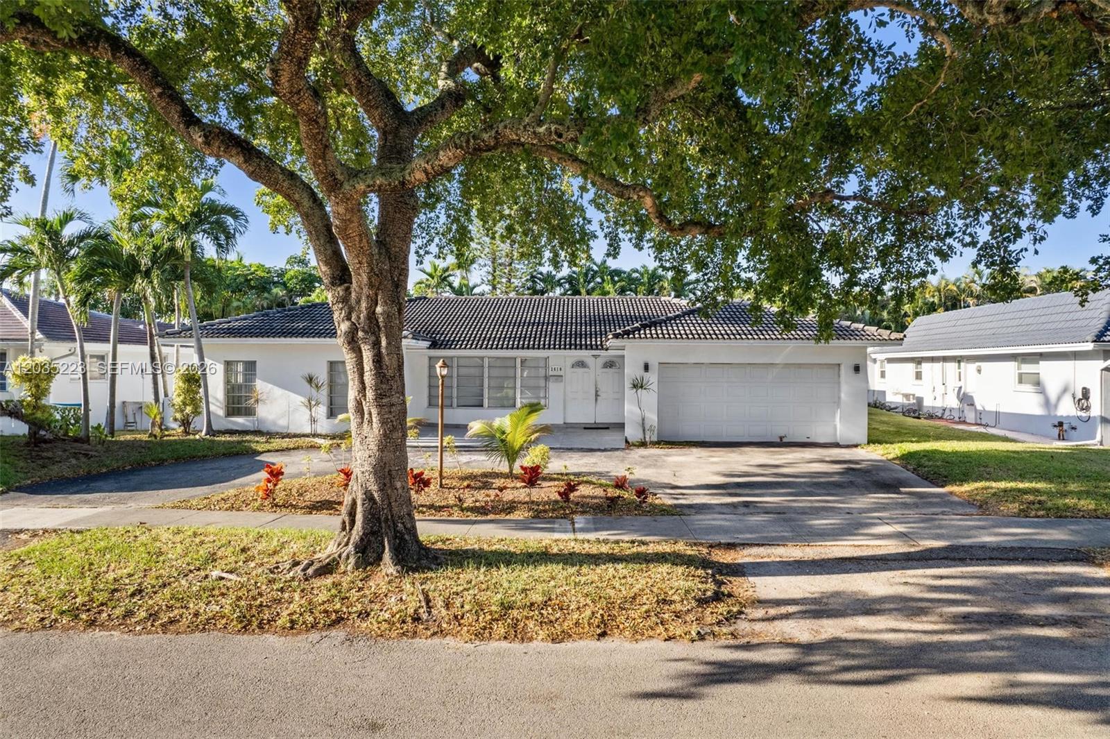 A single-story white house with a tile roof and a large tree in the yard — 3610 N 53rd Ave, Hollywood FL 33021, HOLLYWOOD, FL