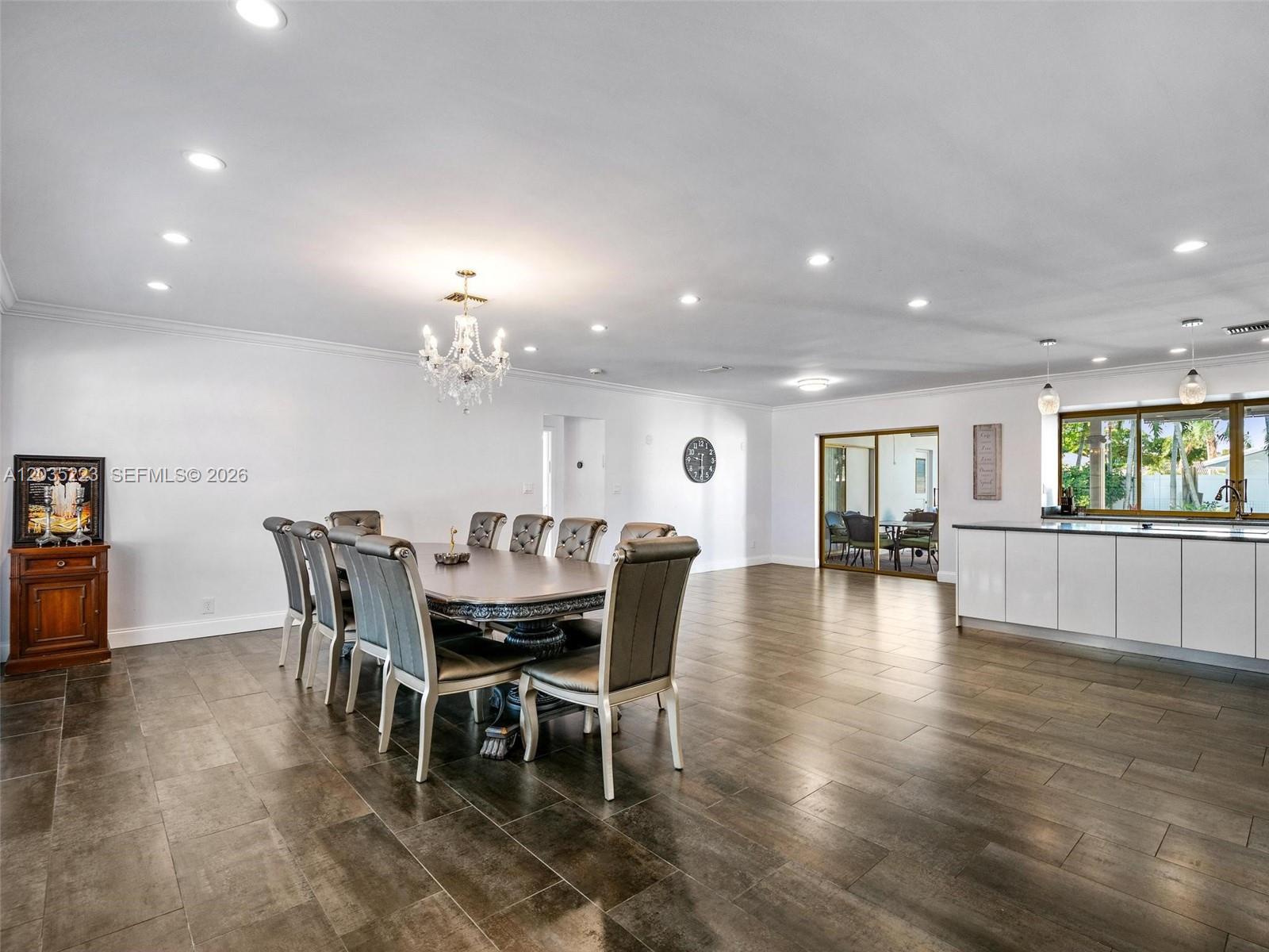 A dining area with a chandelier and table sits next to a kitchen island — 3610 N 53rd Ave, Hollywood FL 33021, HOLLYWOOD, FL