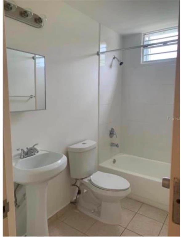 A bathroom with a pedestal sink, a toilet, and a shower-tub combination with white tiles — Apartments MONTESOL UNIT E-312, FAJARDO, PR