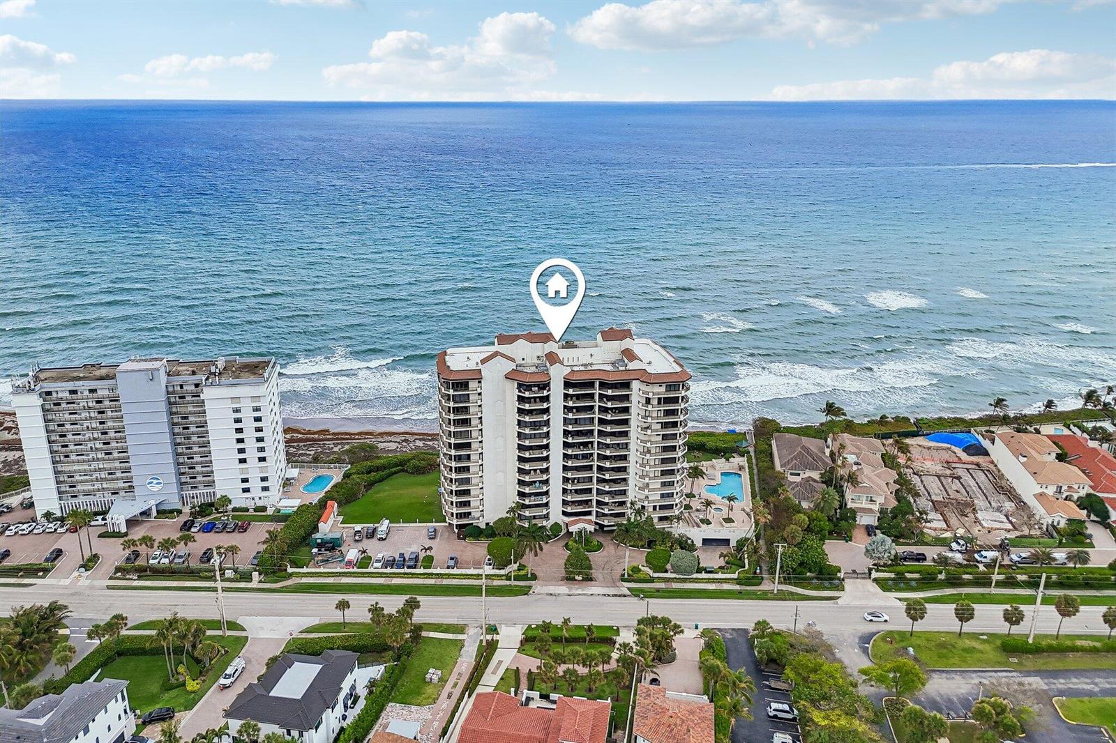 An aerial view shows a beachfront high-rise condominium building with a pool and parking lot — 800 Ocean Drive # 1105, Juno Beach FL 33408, JUNO BEACH, FL