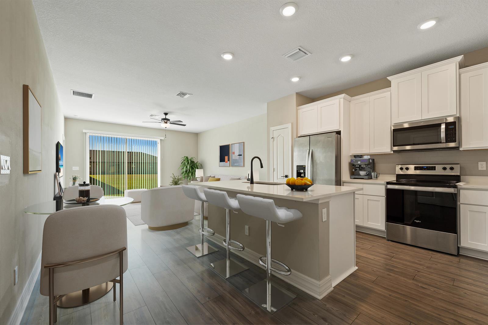 A modern kitchen with white cabinets, stainless steel appliances, and an island with bar seating — 1817 Party Place, Fort Pierce FL 34947, FORT PIERCE, FL