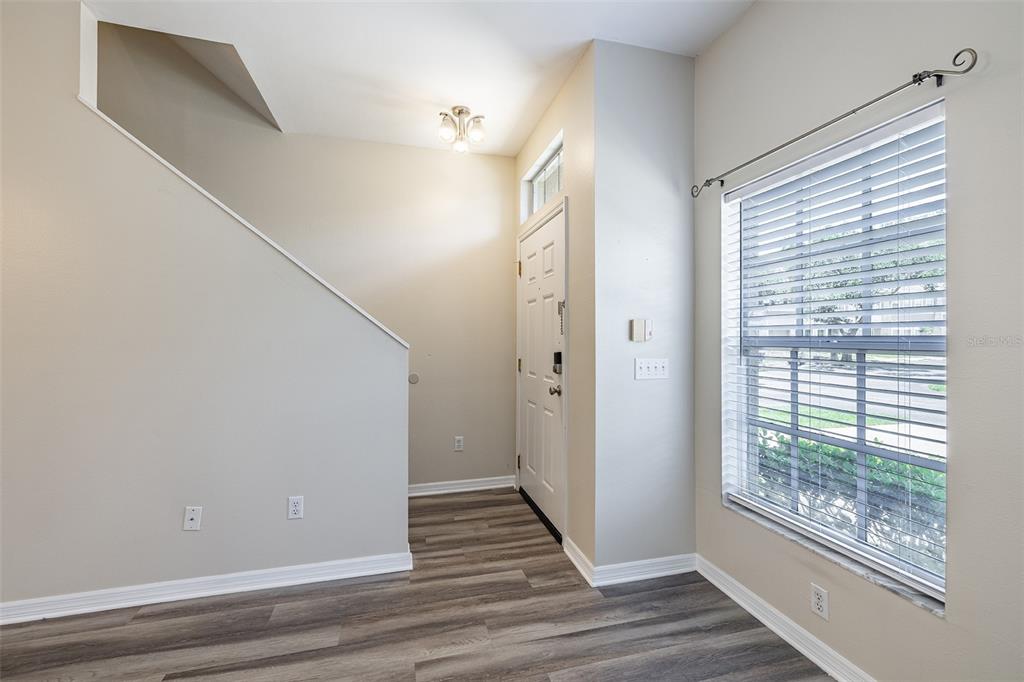 An entryway with wood-look flooring, a staircase, a front door, and a large window — 4310 FINCASTLE COURT, TAMPA, FL