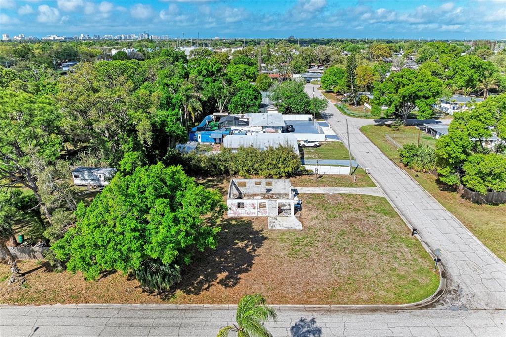 An aerial view shows a vacant lot with a dilapidated, roofless structure and surrounding trees — 0 DOVER STREET, SARASOTA, FL