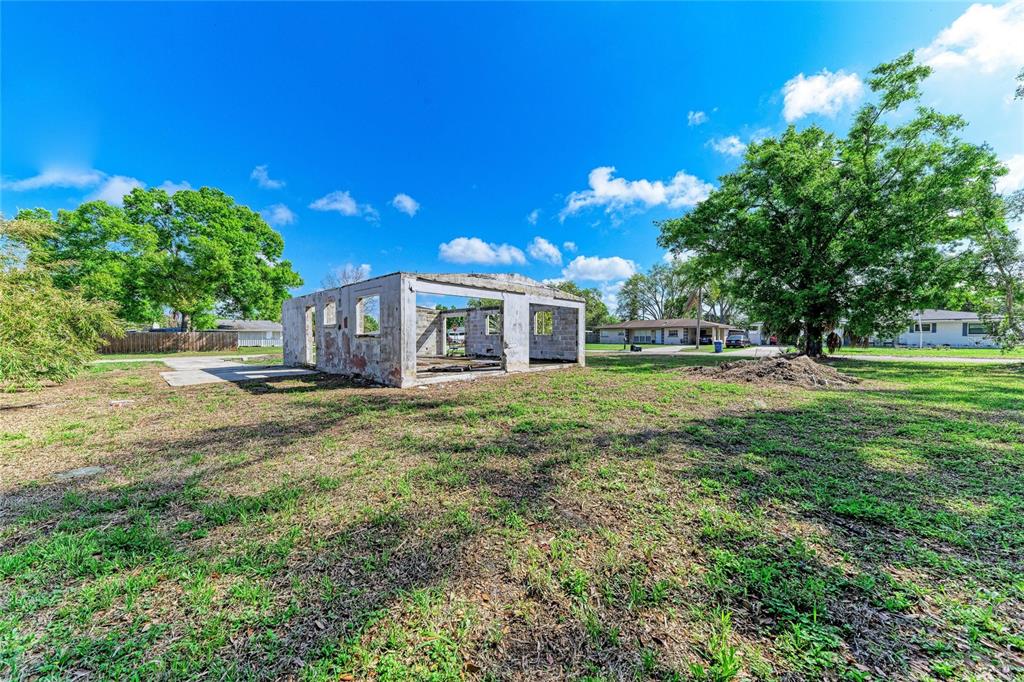 A dilapidated concrete block structure stands in a grassy lot under a blue sky — 0 DOVER STREET, SARASOTA, FL