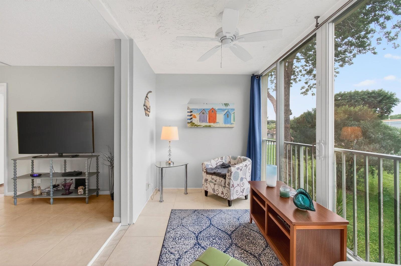 A sunroom with tile flooring, a ceiling fan, and a sliding glass door to a balcony — 10 Willowbrook # 205, Delray Beach FL 33446, DELRAY BEACH, FL