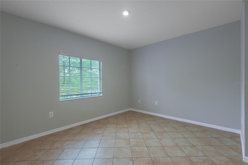 An empty room features light gray walls, tan tile flooring, and a single window — 6007 SKYDALE WAY UNIT 201, RIVERVIEW, FL