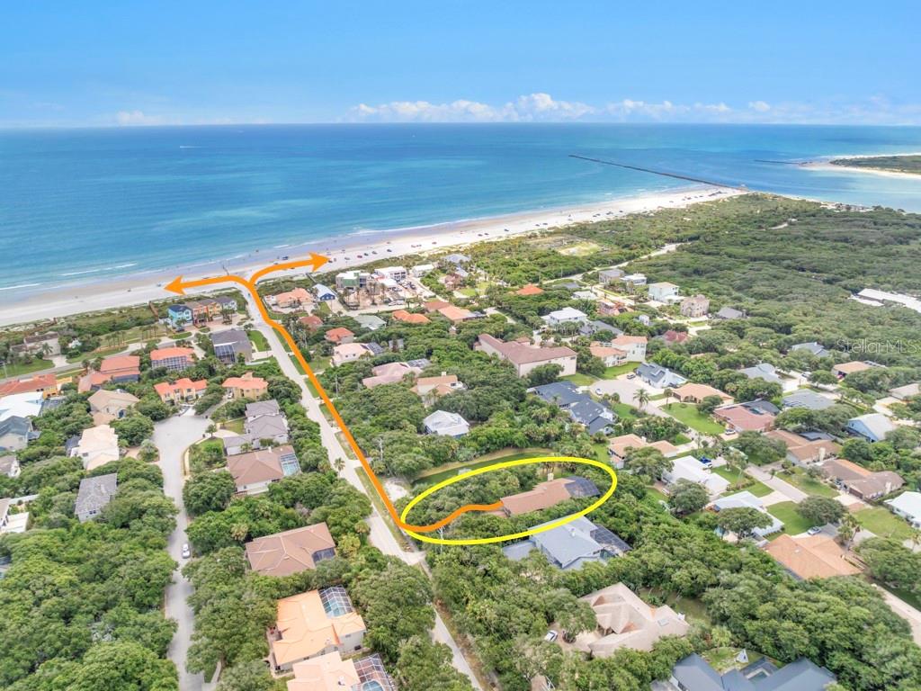 An aerial view shows a residential house surrounded by trees near a sandy beach — 59 BEACH STREET, PONCE INLET, FL