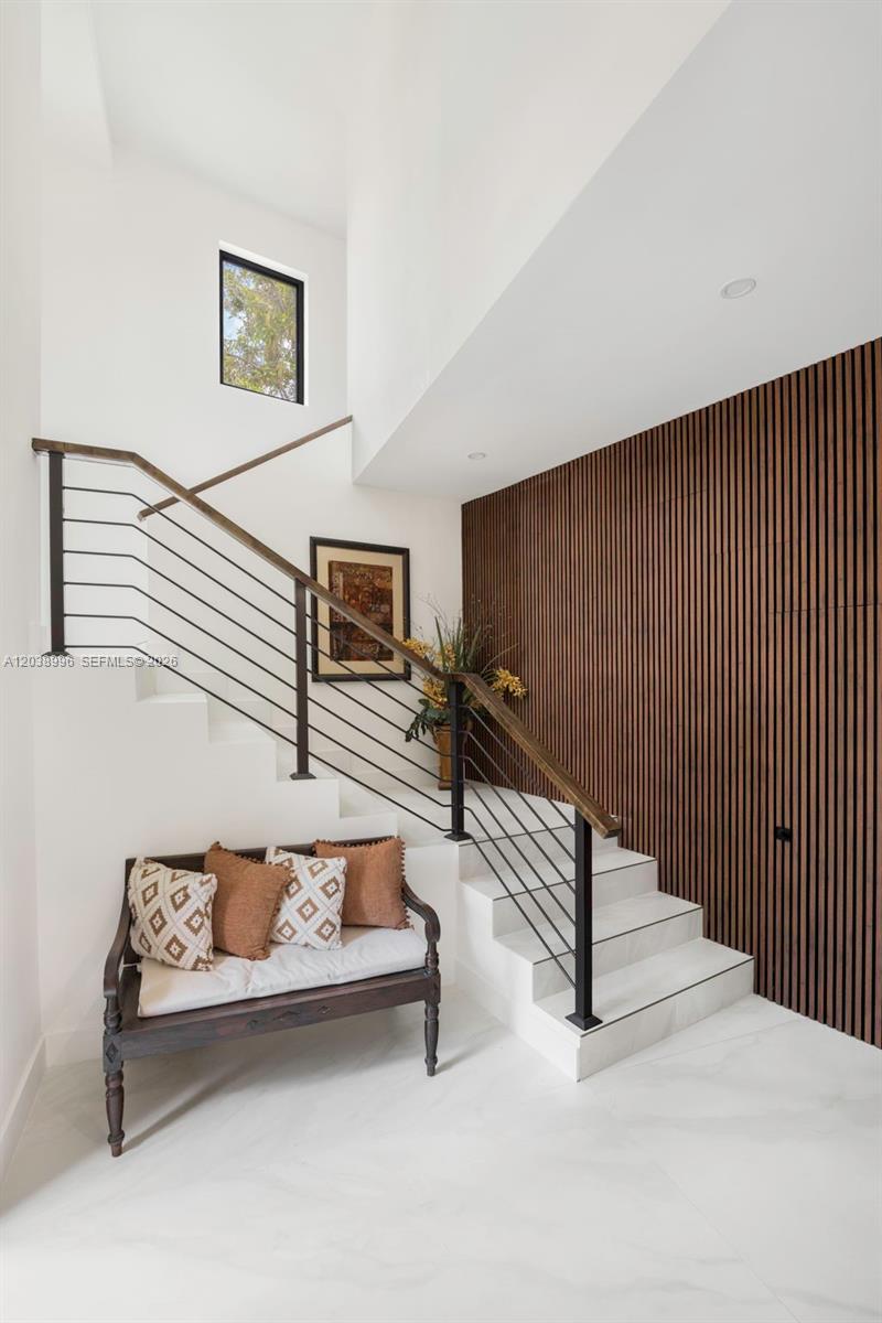 A staircase with a metal railing and wood handrail sits beside a slatted wood wall — 3303 Halissee St, Coconut Grove FL 33133, COCONUT GROVE, FL