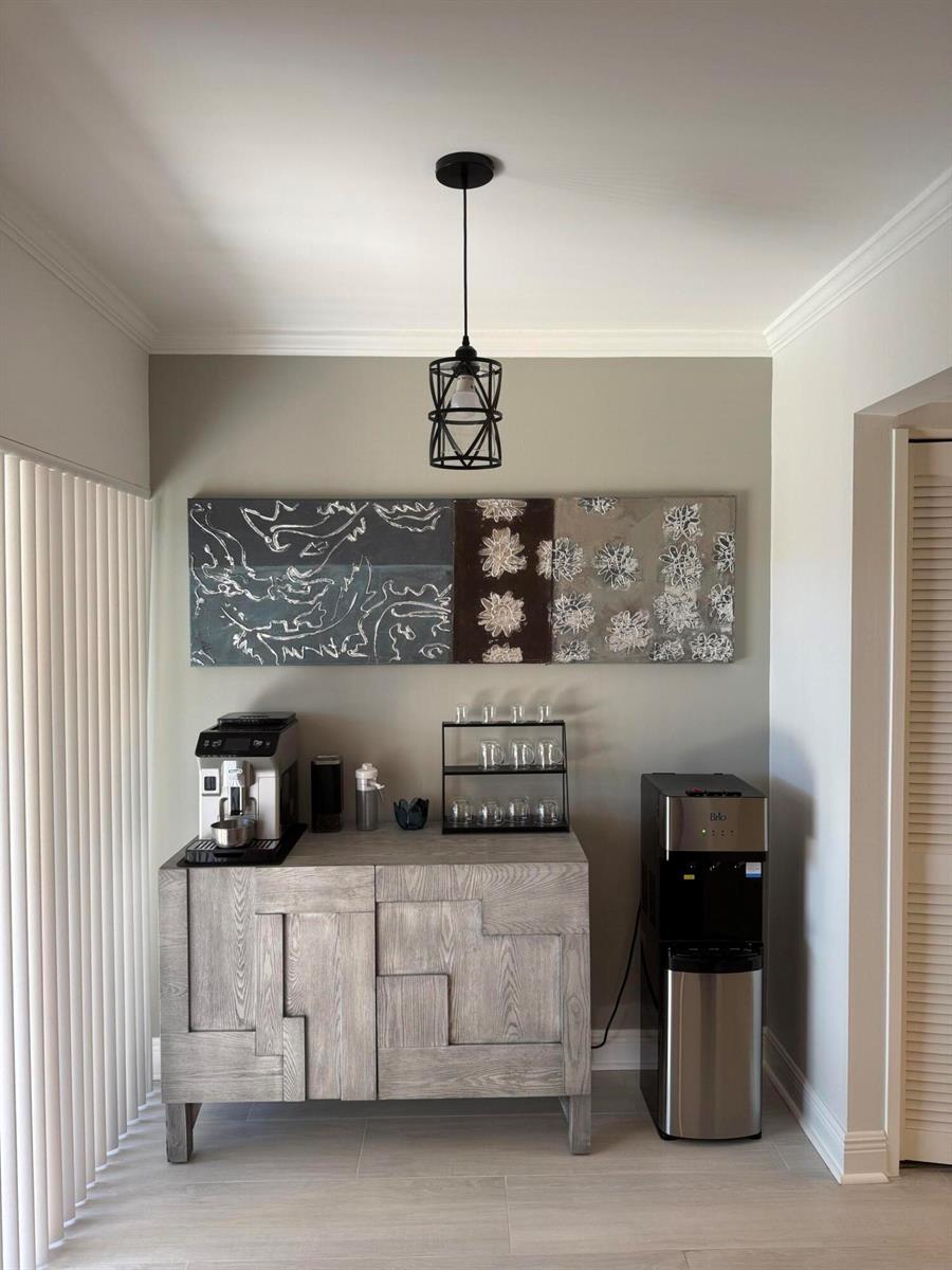 A coffee station features a gray wooden cabinet, a water cooler, and wall-mounted artwork — 5644 Santiago Circle, Boca Raton FL 33433, BOCA RATON, FL