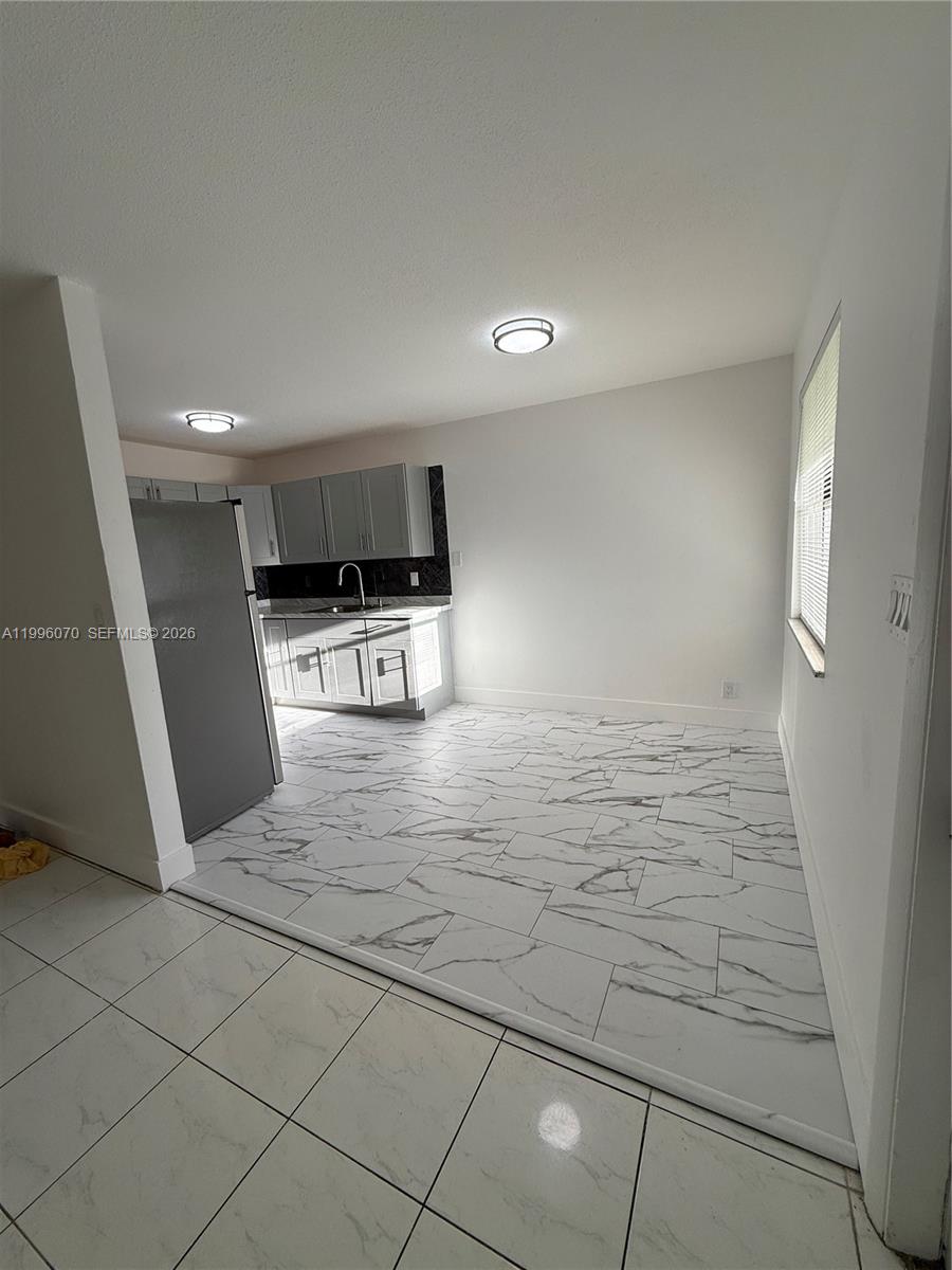 A kitchen features gray cabinets, stainless steel appliances, and white marble-patterned tile flooring — 6071 SW 33rd St # 4, Miramar FL 33023, MIRAMAR, FL