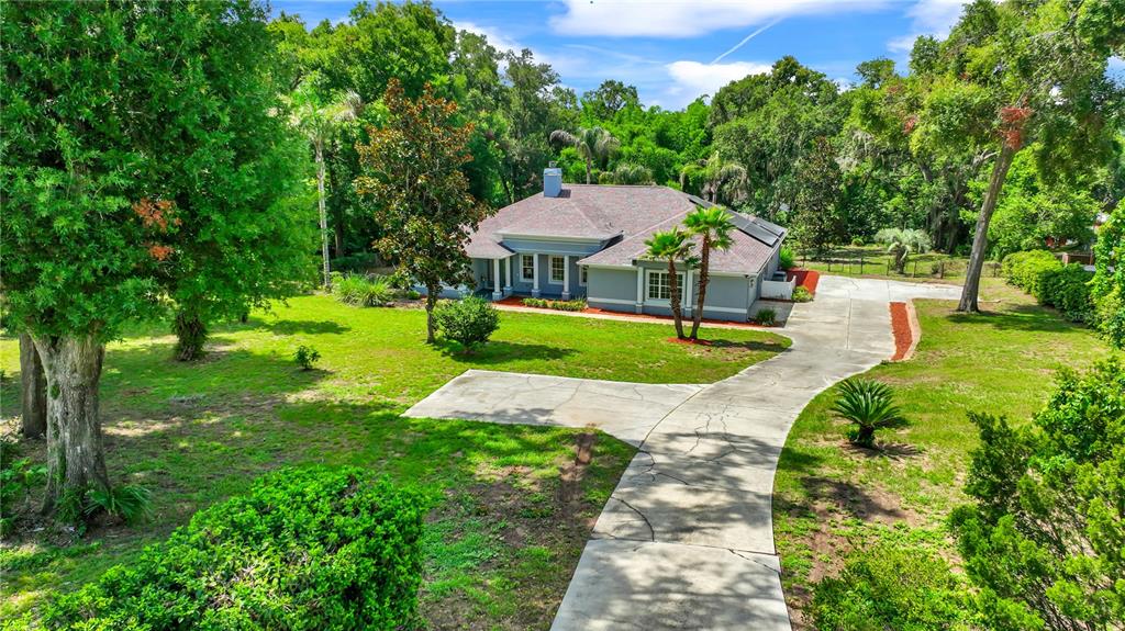An aerial view shows a gray house with a shingled roof and a concrete driveway — 36510 SAINT JOE ROAD, DADE CITY, FL