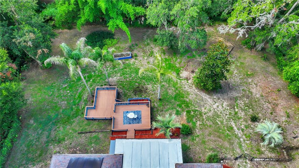 An aerial view shows a house with a multi-level wooden deck and a large backyard — 36510 SAINT JOE ROAD, DADE CITY, FL