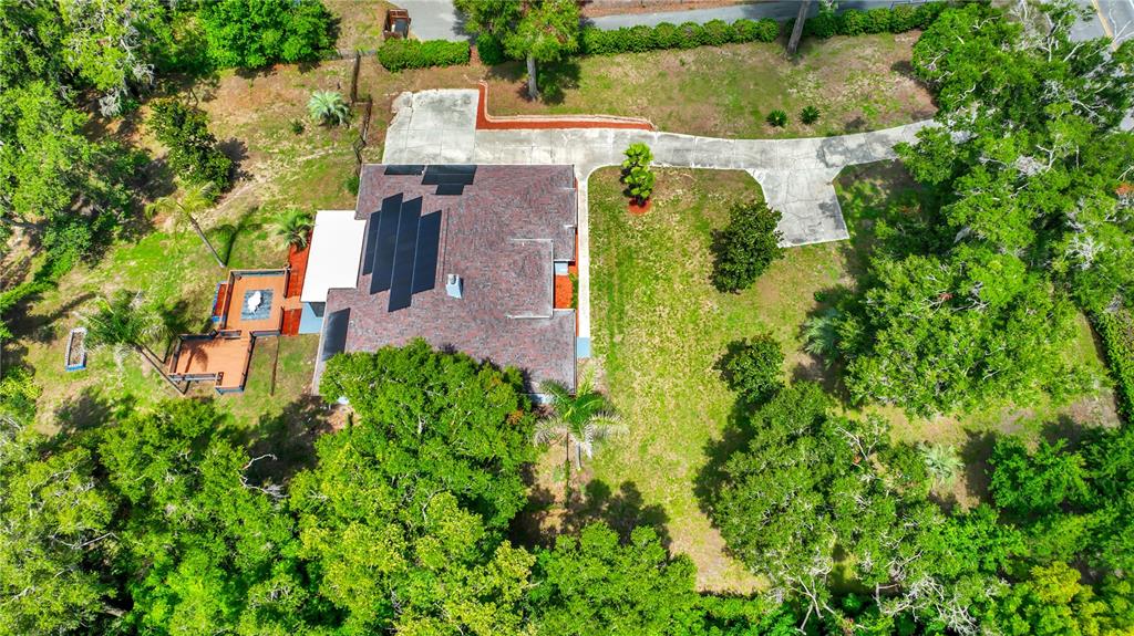 An aerial view shows a house with solar panels, a wooden deck, and a concrete driveway — 36510 SAINT JOE ROAD, DADE CITY, FL