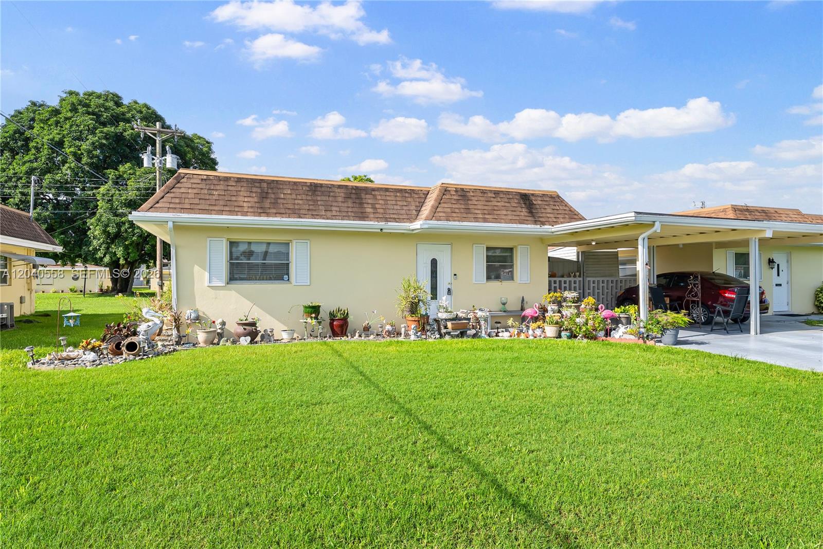 A single-story house with a yellow exterior, brown roof, and a covered carport — 2208 Gardenia Way, Lehigh Acres FL 33936, LEHIGH ACRES, FL