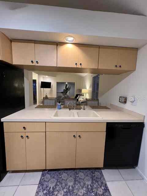 A kitchen features light wood cabinets, a white double sink, and a black dishwasher — 3761 LAKE SHORE DRIVE, PALM HARBOR, FL