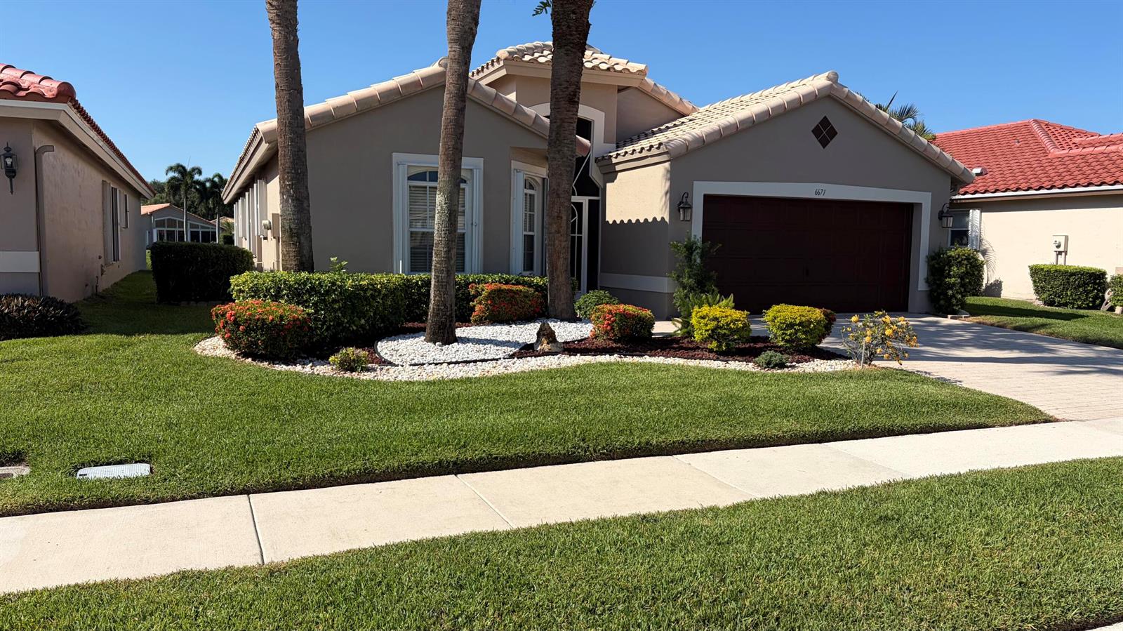 A single-story house with a beige stucco exterior, a tile roof, and a landscaped front yard — 6671 Maybrook Road, Boynton Beach FL 33437, BOYNTON BEACH, FL