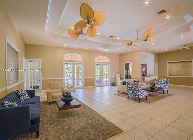 A spacious living room features tile floors, two ceiling fans, and multiple seating areas — 5580 NW 61st St # 602, Coconut Creek FL 33073, COCONUT CREEK, FL