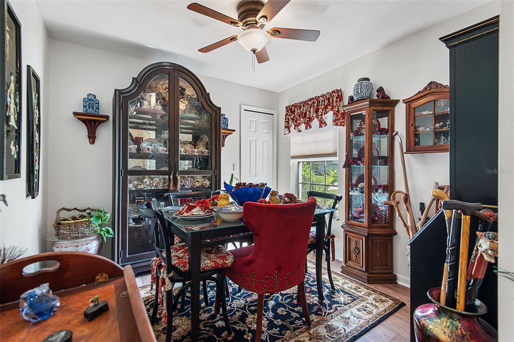 A dining room features a glass-top table, red upholstered chairs, and two wooden display cabinets — 210 ULLIAN TRAIL, PALM COAST, FL