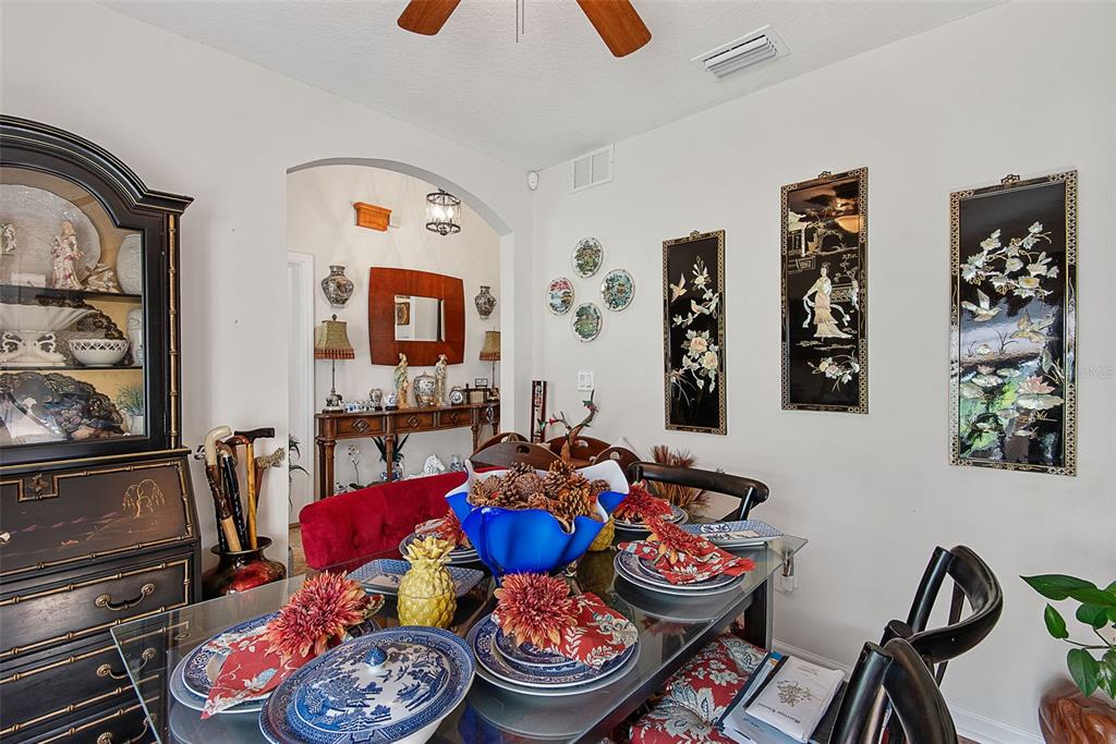 A dining room features a glass table, black furniture, wall art, and a red bench — 210 ULLIAN TRAIL, PALM COAST, FL