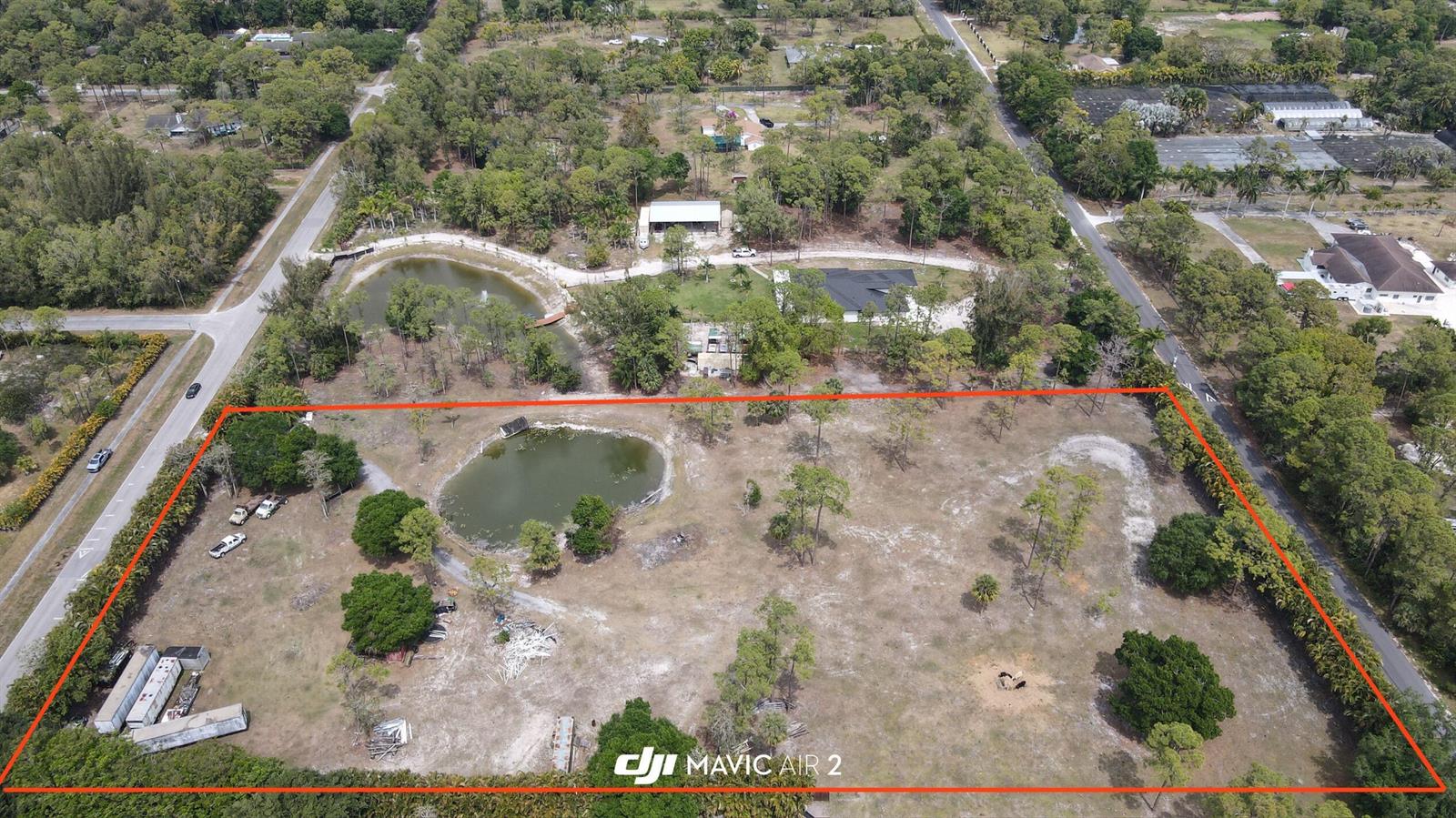 An aerial view shows a large, partially wooded lot with a pond and several structures — 3547 161st Terrace N, FL 33470, FL