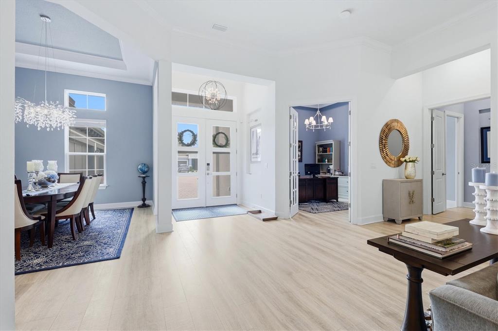 A bright foyer with light wood flooring leads to a dining room and home office — 9463 TEQUILA SUNRISE DRIVE, SARASOTA, FL