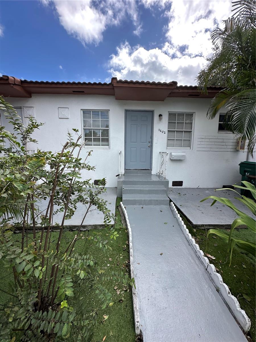 A white single-story building exterior features a gray front door, steps, and a walkway — 600 SW 16th Ave, Miami FL 33135, MIAMI, FL