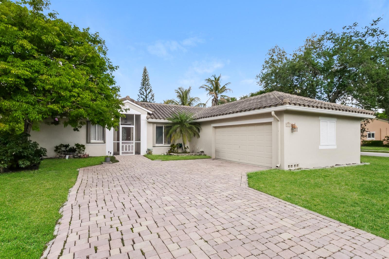 A single-story house with a beige exterior, a tiled roof, and a paved brick driveway — 5491 NW 40th Terrace, Coconut Creek FL 33073, COCONUT CREEK, FL