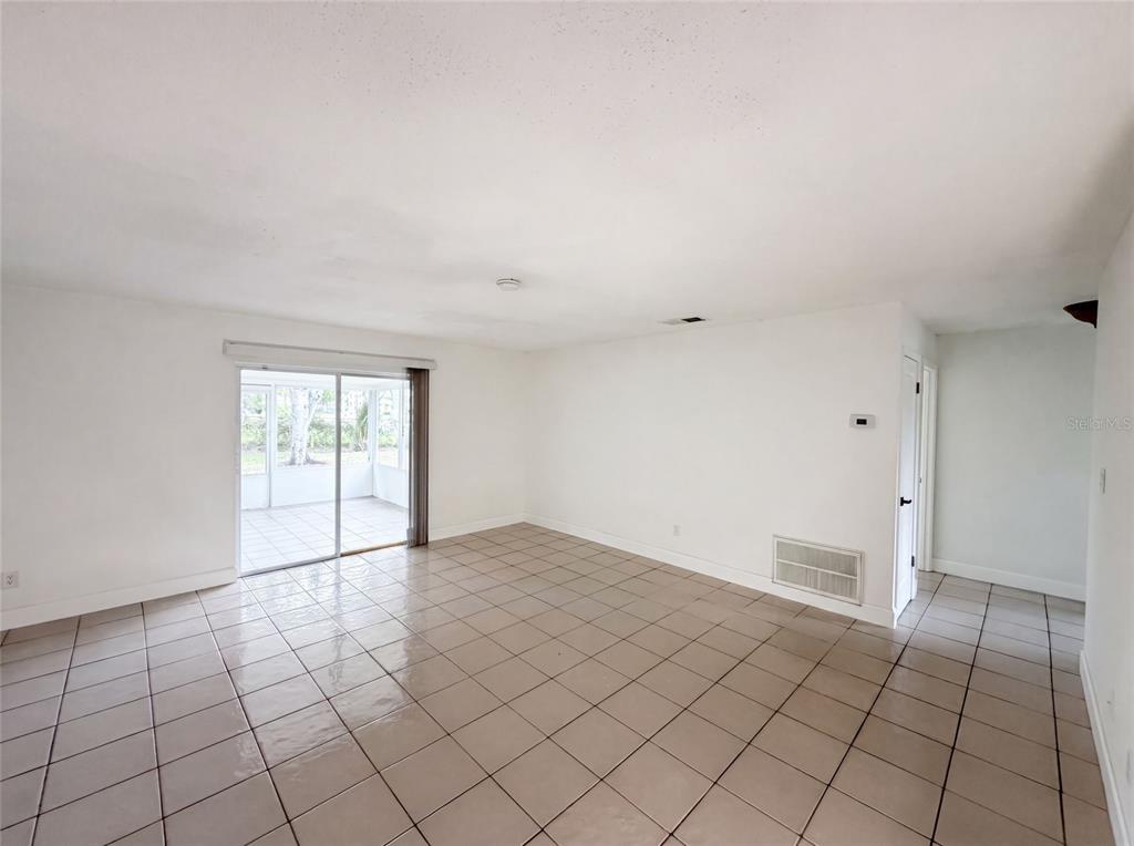 An empty room with white walls, tile flooring, and a sliding glass door to a patio — 2401 MYAKKA DRIVE, ORLANDO, FL