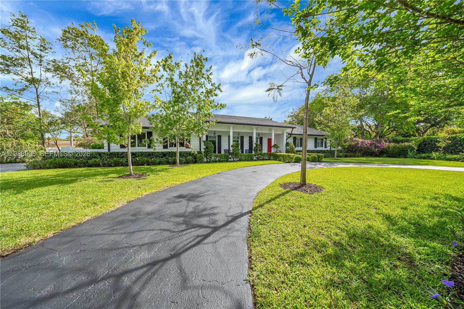 A single-story white house with a dark roof and a curved asphalt driveway — 10705 SW 128th Ter, Miami FL 33176, MIAMI, FL