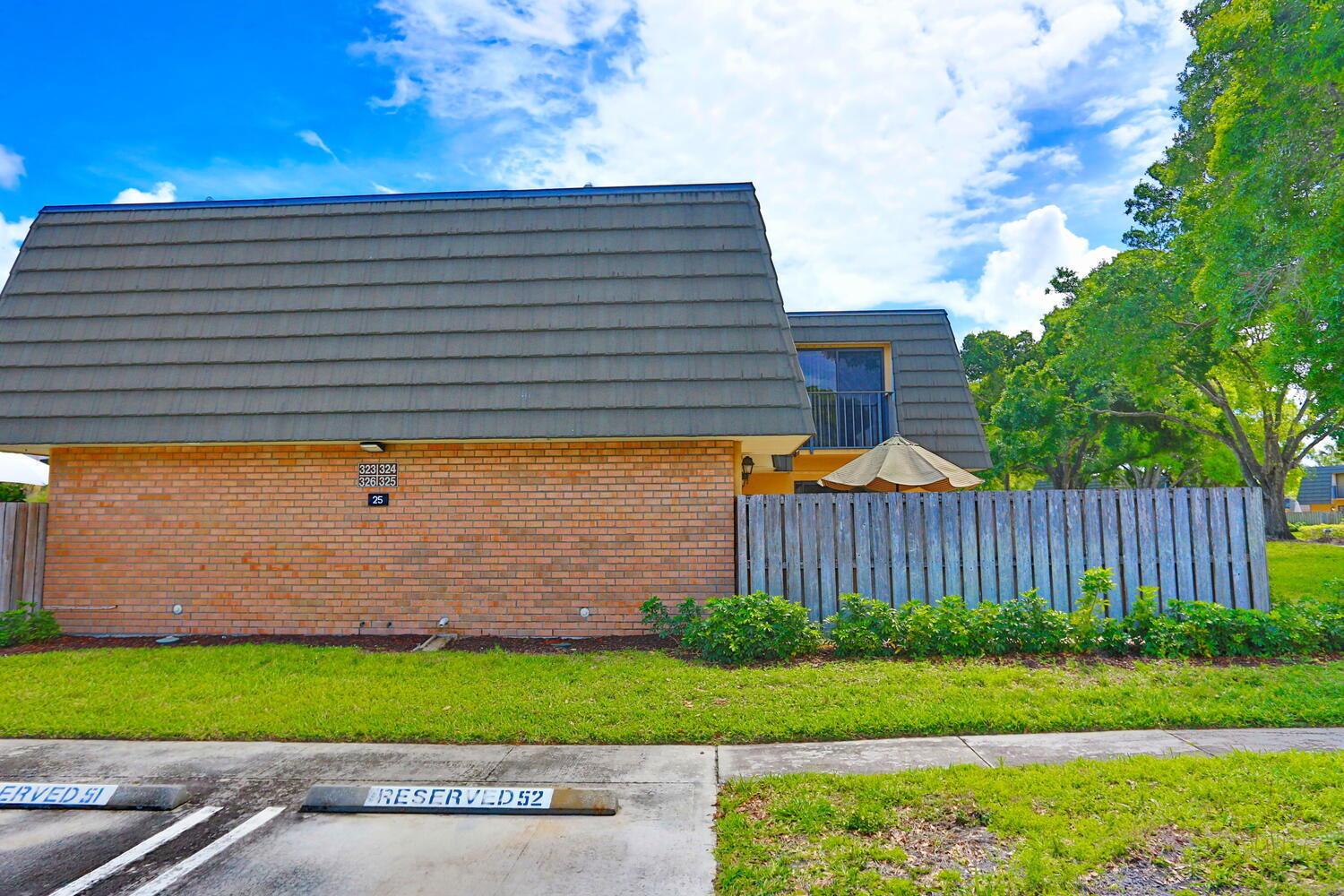 A two-story brick apartment building with a gray shingled roof and a wooden privacy fence — 325 3rd Way, West Palm Beach FL 33407, WEST PALM BEACH, FL