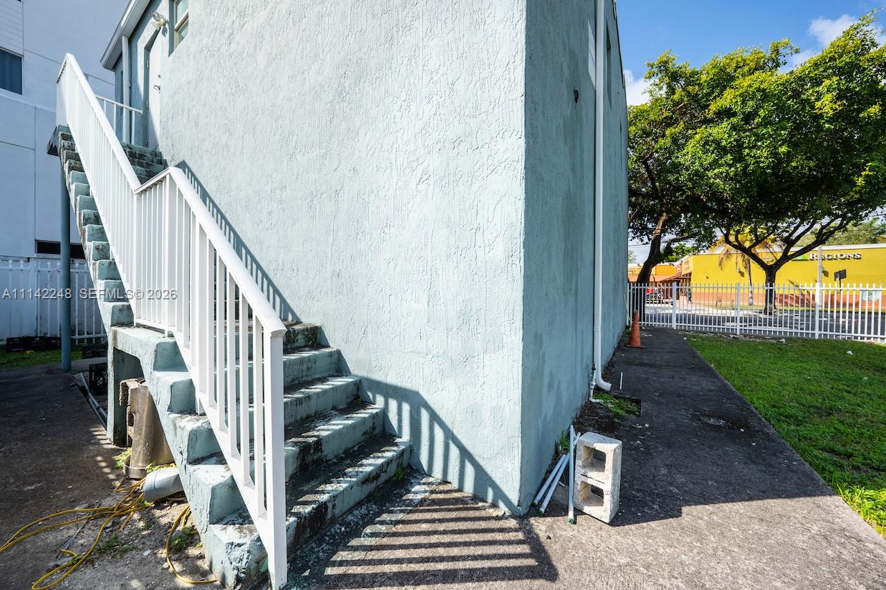 An exterior view shows a light blue building with an outdoor staircase and a concrete walkway — 1525 NW 3rd Ave, Miami FL 33136, MIAMI, FL