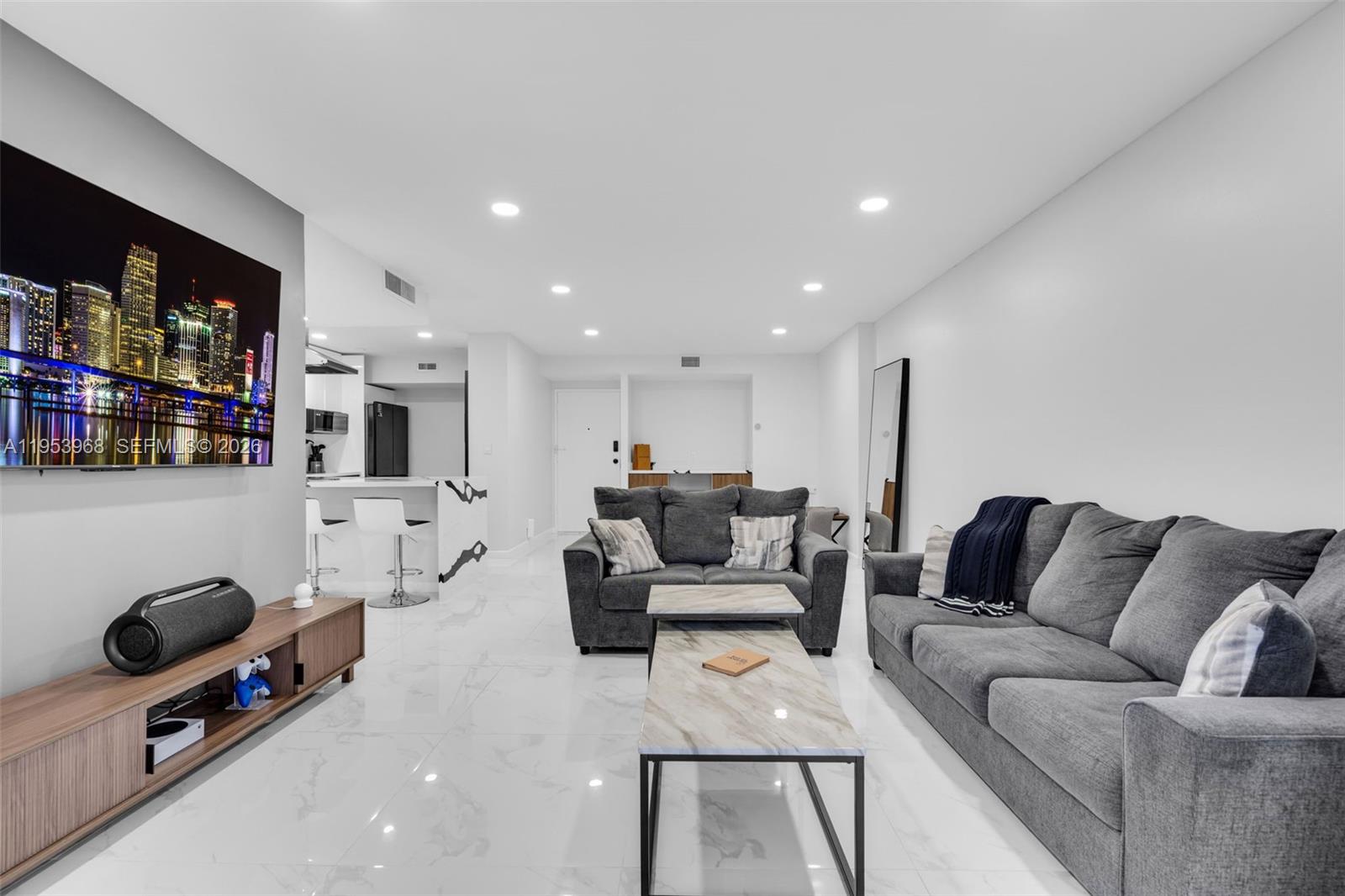 A modern living room features gray sofas, a marble coffee table, and white tile flooring — 3800 Hillcrest Dr # 203, Hollywood FL 33021, HOLLYWOOD, FL